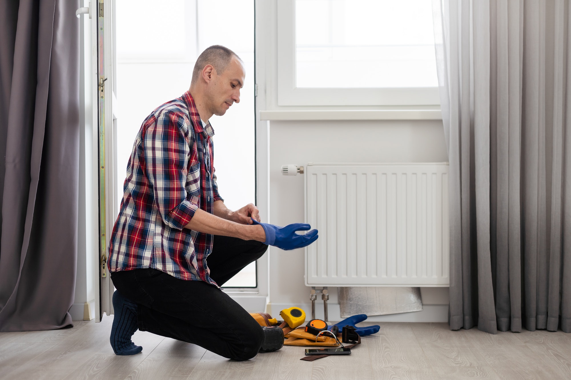 plumber at work. Installing water heating radiator